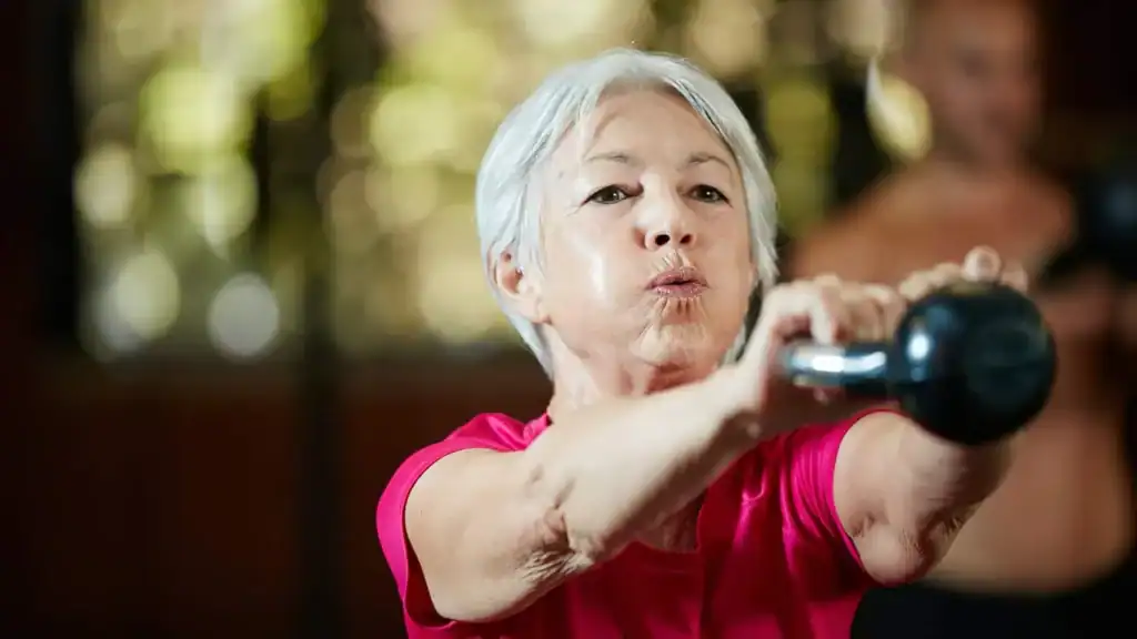 Older woman doing weight training Stanford-le-Hope to help her strength and longevity 