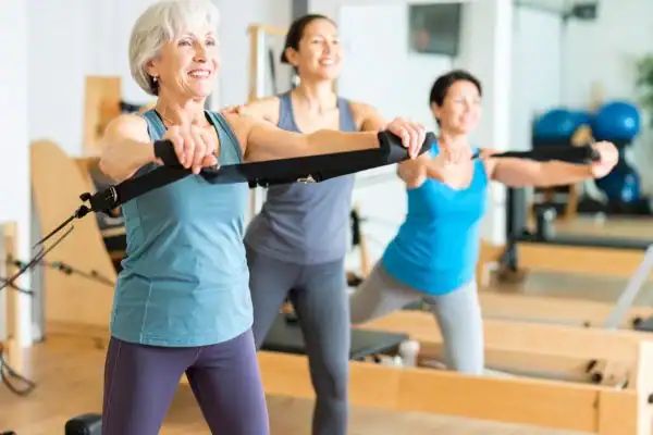 Toning Arms After 60: Empowering Womens Fitness Through Effective Weight Training 2 older woman doing weight training Stanford-le-Hope and resistance in the gym to tone upper arms