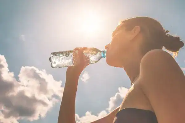 Hydration: The Secret Ingredient for a Toned Stomach and Enhanced Fitness 3 Image of woman drinking water to hydrate Stanford-le-Hope after run.