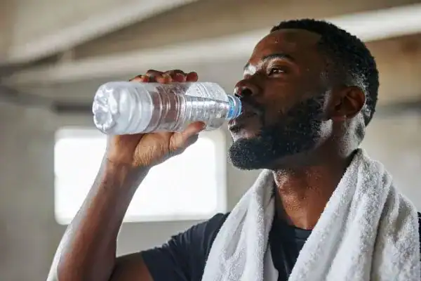 Hydration: The Secret Ingredient for a Toned Stomach and Enhanced Fitness 1 Image of man drinking water to improve hydration Stanford-le-Hope after work out.